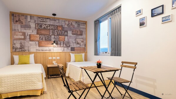 Un dormitorio con dos camas, una mesa de madera y una ventana con cortinas.