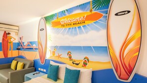 Una habitación con temática de playa, que incluye un mural, un sofá y una cama.