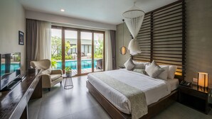 A modern hotel room with a large bed, a TV, a desk, and a view of a pool and greenery. - Ren Resort (Sihanoukville)