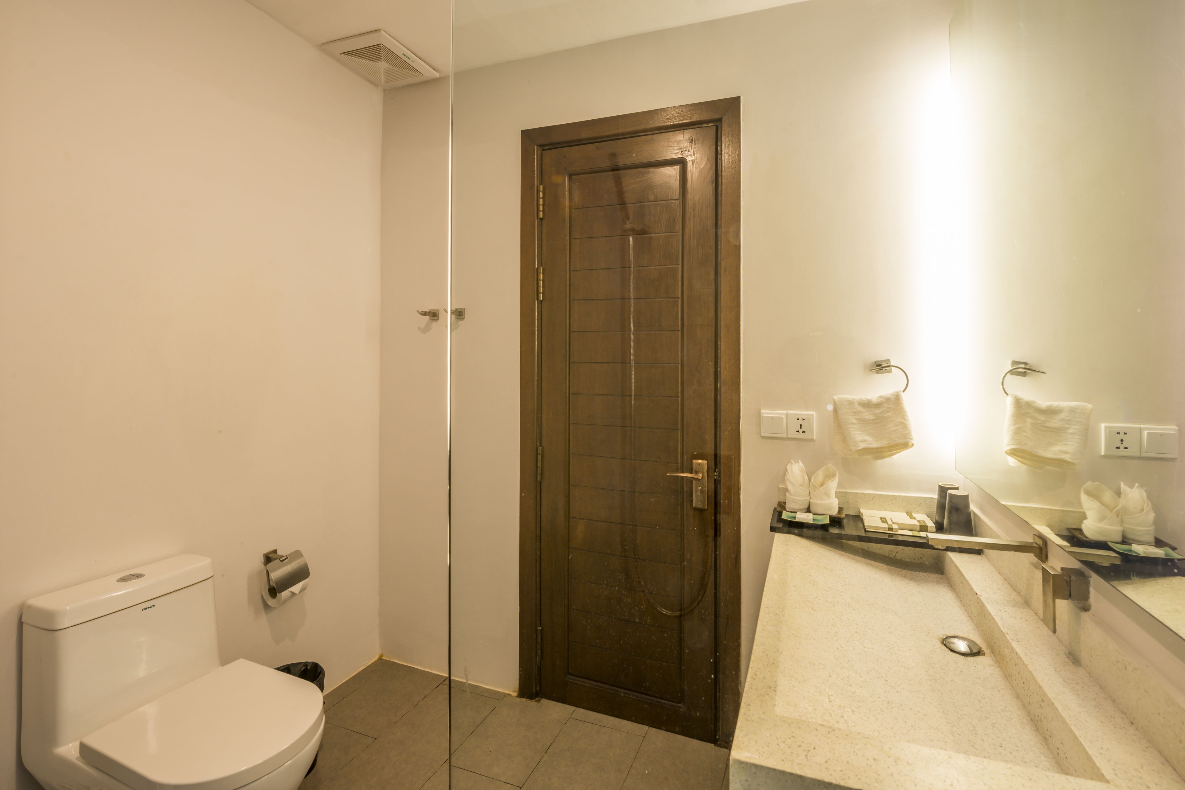 Ein Badezimmer mit Toilette, Dusche und Waschbecken mit Spiegel.