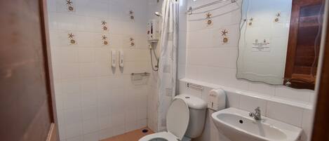 Un baño moderno con inodoro, ducha y lavabo.