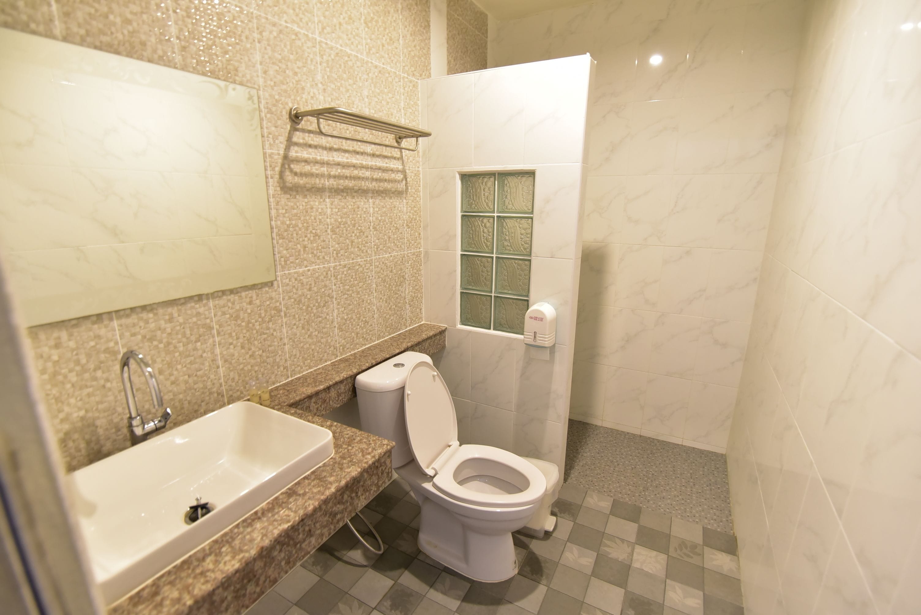 A bathroom with a sink, toilet, and shower area.