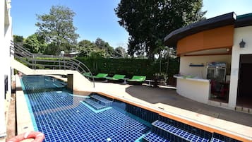 Alberca al aire libre y camastros