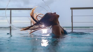 En person i en swimmingpool med vandstænk omkring.