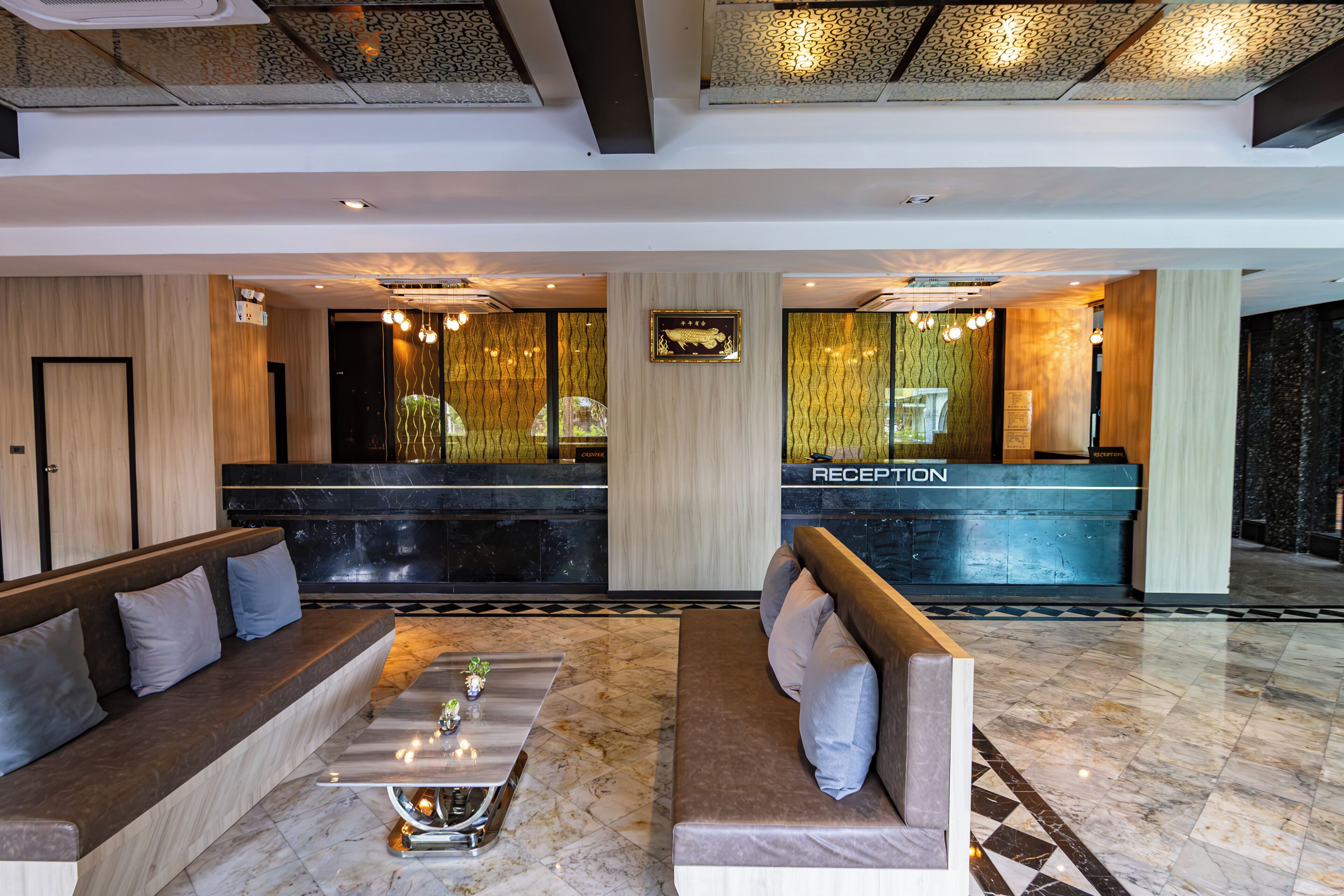 A hotel lobby with a reception desk, seating area, and a reception sign.