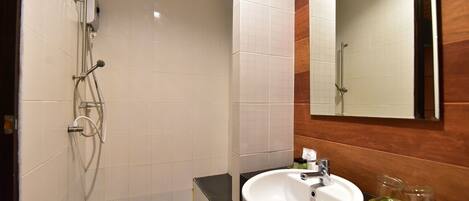 A bathroom with a shower, a sink, and a mirror.