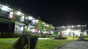 A multi-story hotel with balconies, a well-lit entrance, and a landscaped garden area. - The Breeze Lipe Resort (Koh Lipe)