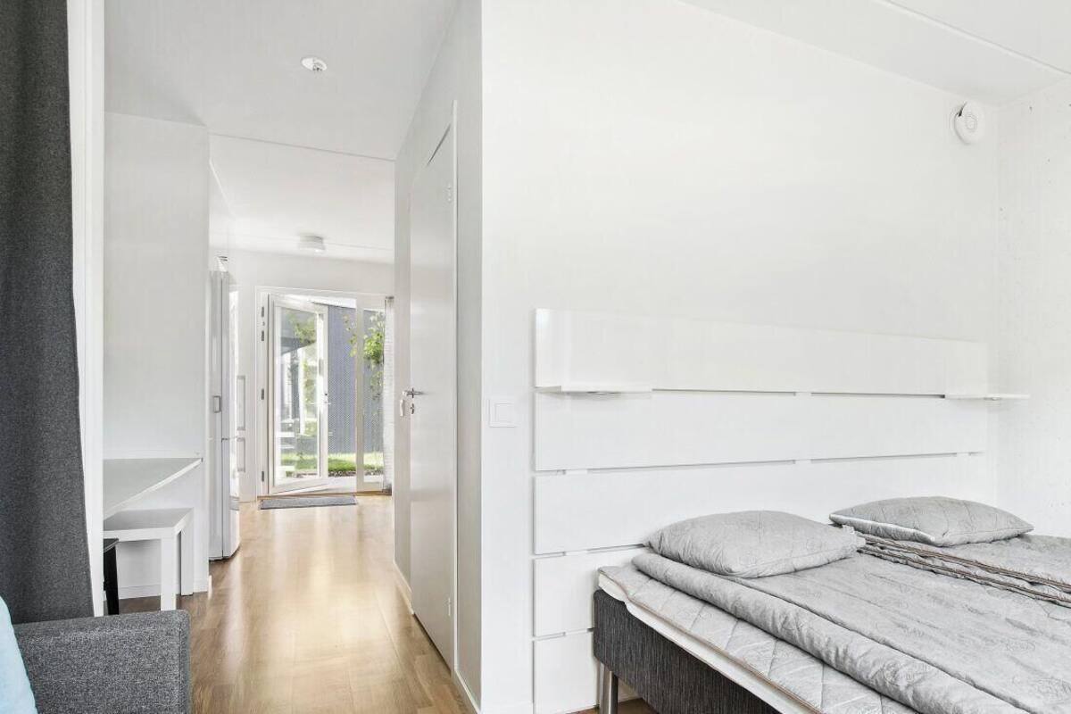 A modern bedroom with a bed, a desk, and a chair.