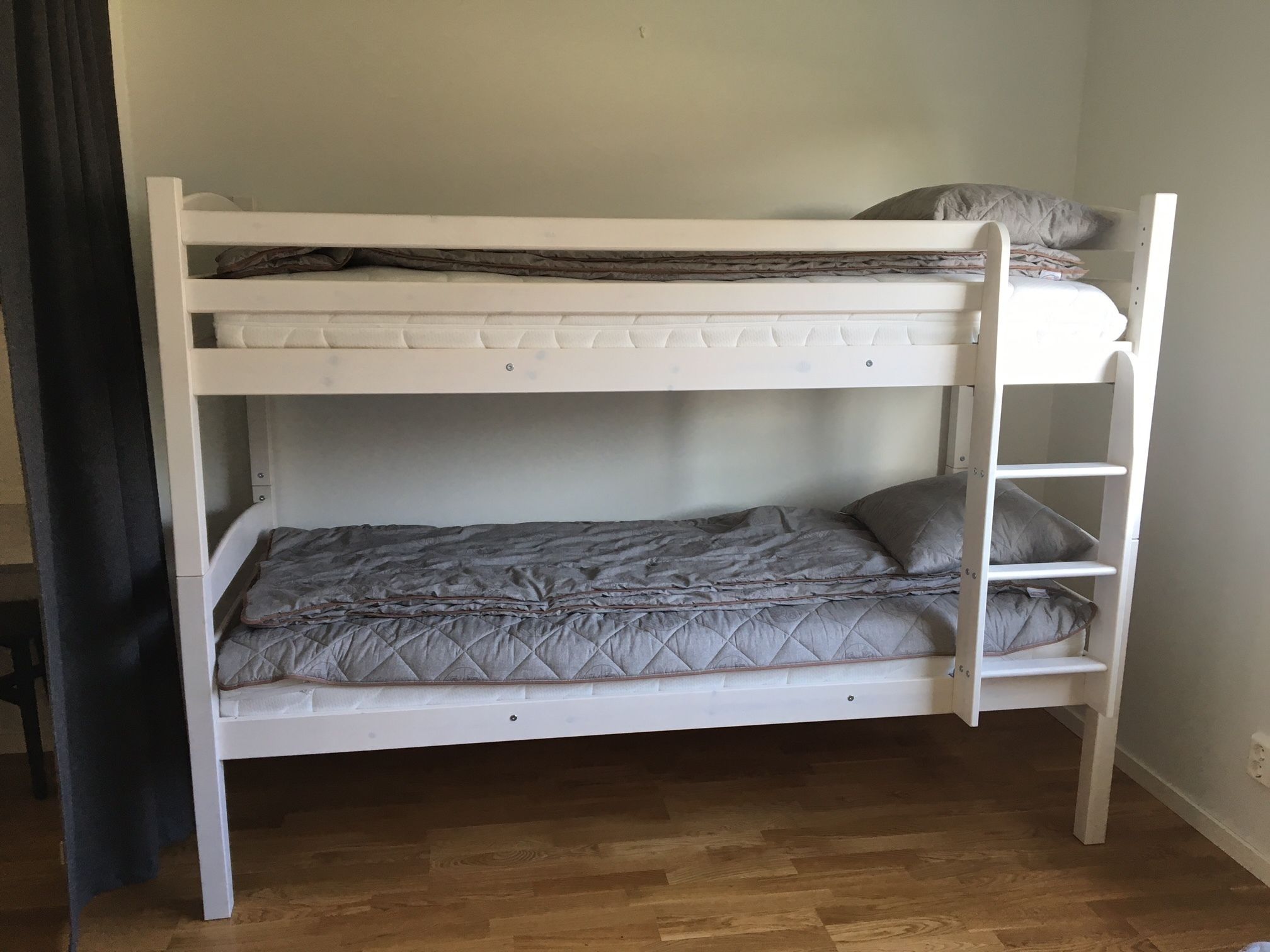Een stapelbed met een matras en kussens op het bovenste bed.