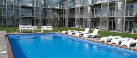 Piscine extérieure en saison, chaises longues