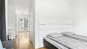 Un dormitorio moderno con cama, escritorio y silla.