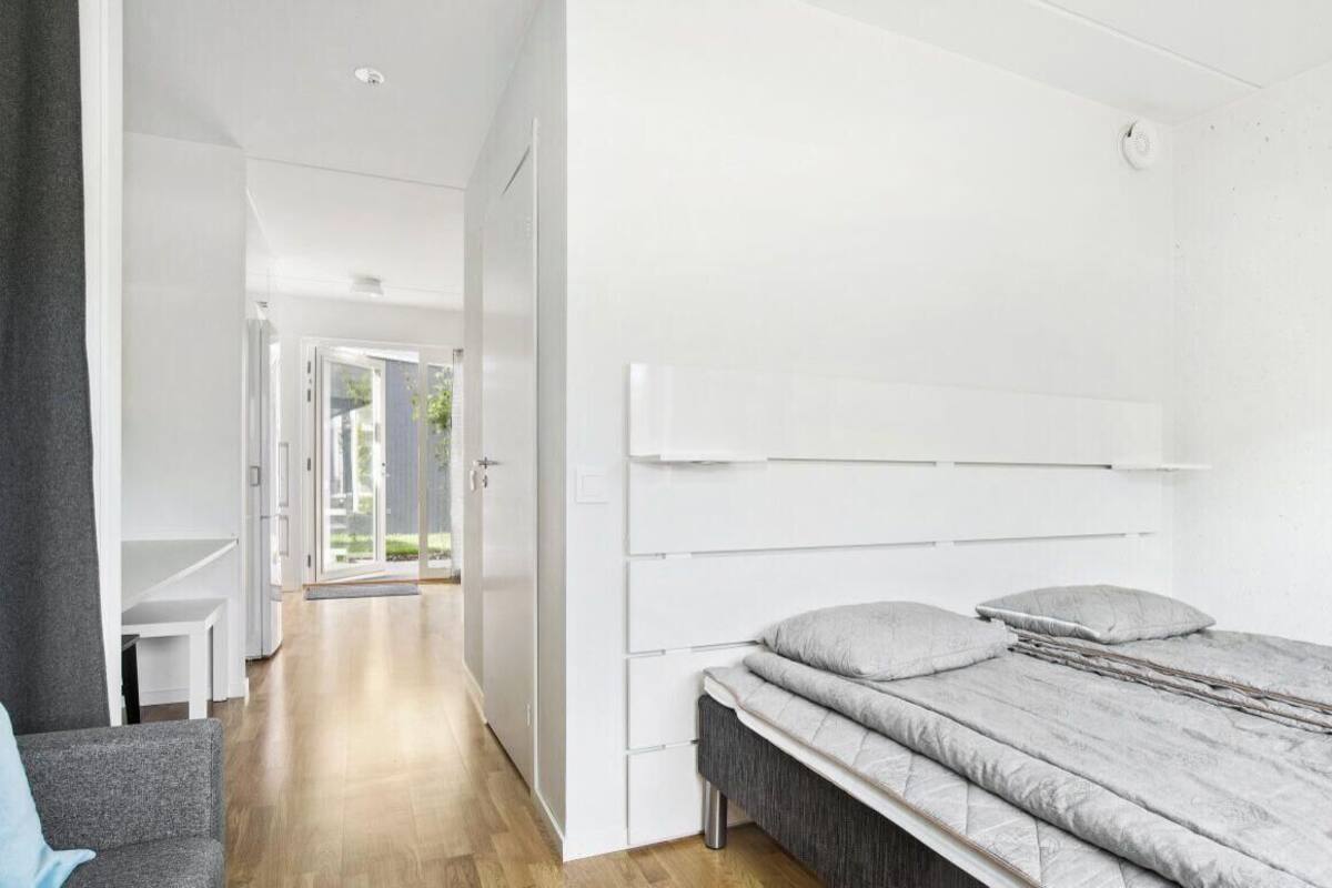 A modern bedroom with a bed, a desk, and a chair.