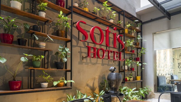 A hotel interior with a large sign reading "SOTIS HOTEL" and multiple shelves with potted plants. - Sotis Hotel Falatehan Jakarta (Jakarta)