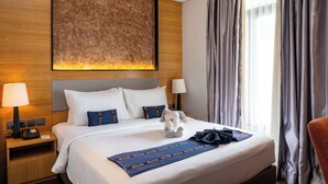 A hotel room with a large bed, a headboard, a nightstand with a lamp, and a window with curtains. - Sotis Hotel Falatehan Jakarta (Jakarta)