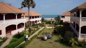 Ein Innenhof mit Pool, Palmen und Blick auf den Ozean.