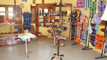 A boutique with various clothing items displayed on racks and tables.