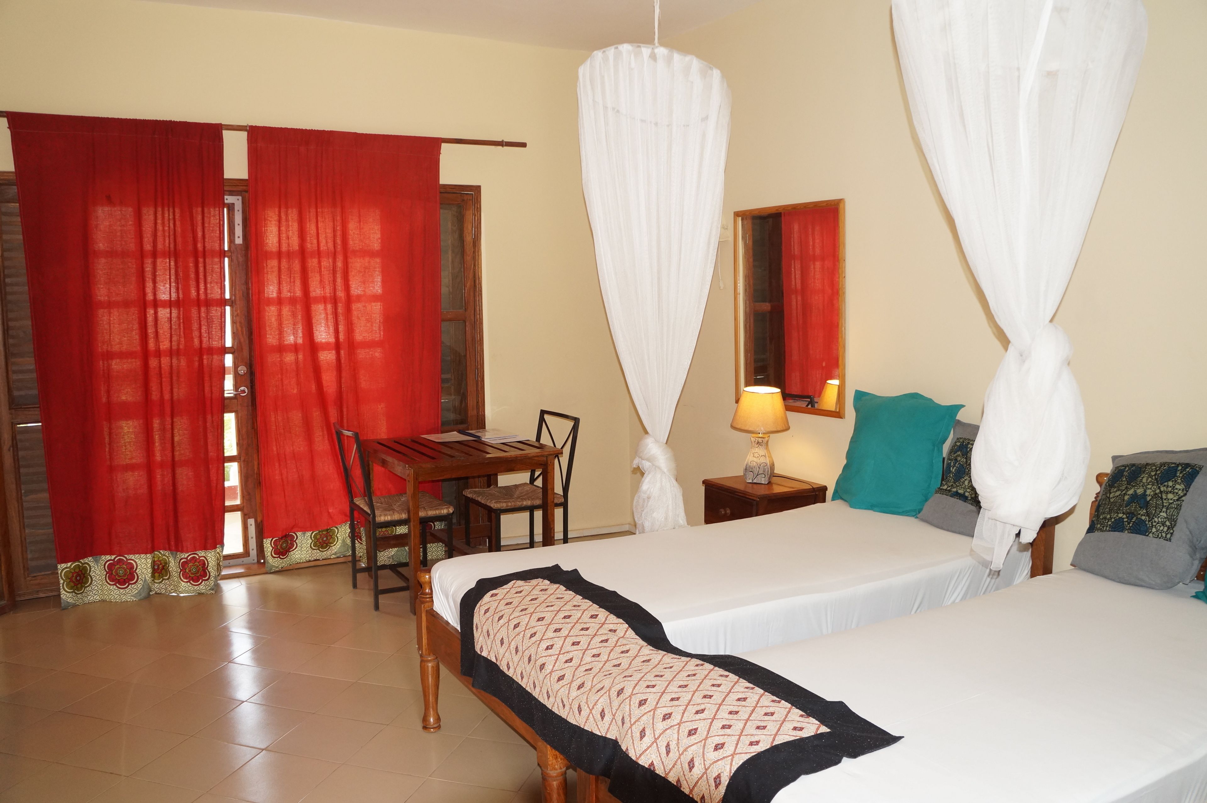 A hotel room with two beds, a desk, and a chair.