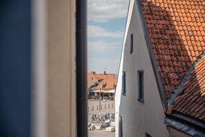 A narrow street with buildings on either side, a clear sky, and a few bicycles parked in the distance. - Stora Torget - Visby Lägenhetshotell  (Visby)