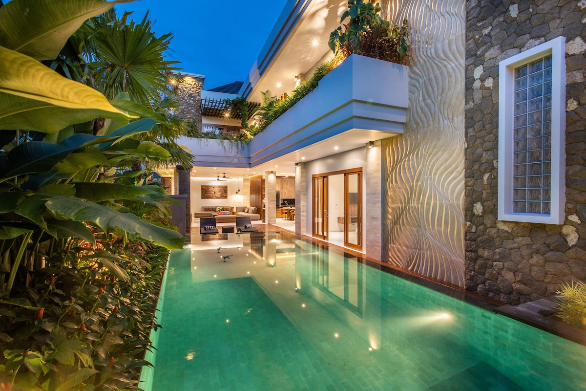 A modern house with a swimming pool, a kitchen, and a living area.