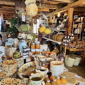 A rustic market stall with various items like jars, baskets, and kitchenware. - STF Ihre Gård (Lärbro)