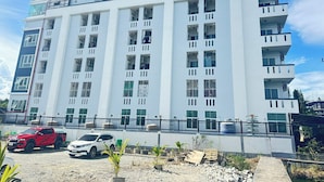 A multi-story building with balconies, large windows, and a flat roof. - At Ease Hotel Suvarnabhumi (Bang Phli)