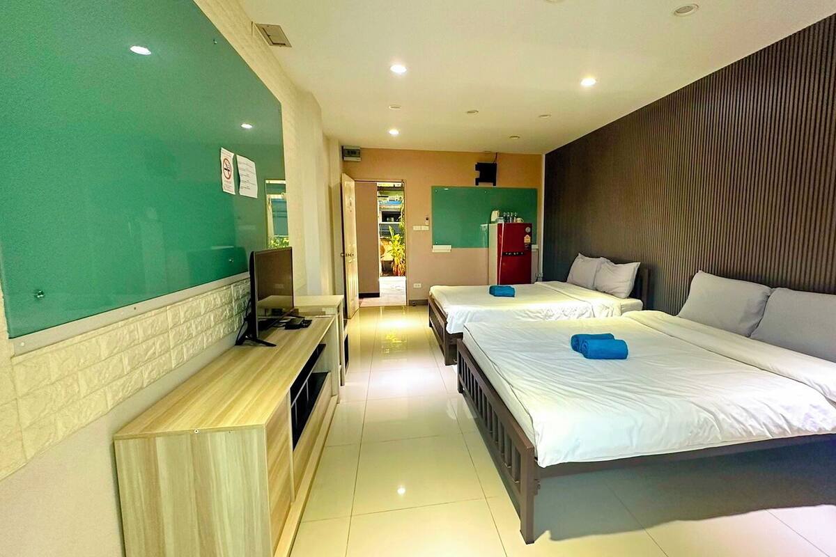 Une chambre d’hôtel avec deux lits, une télévision et une kitchenette.
