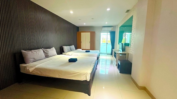 A hotel room with two beds, a desk, a chair, and a view of the outside. - At Ease Hotel Suvarnabhumi (Bang Phli)