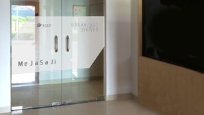 A modern hotel room with a glass partition, a flat-screen TV, and a ceiling-mounted air conditioner. - Zizz Convention Hotel (Dalung)