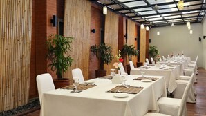 A long dining table set with white tablecloths, chairs, and centerpieces. - Zizz Convention Hotel (Dalung)