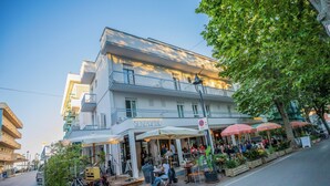Een meerhoog gebouw met terras en een bord waarop 'SENZASPINE' staat.