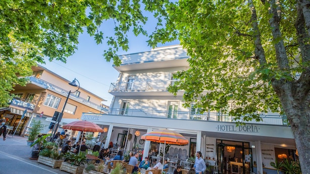 Een hotel met terras, balkon en een bord waarop 'HOTEL DORIA' staat.