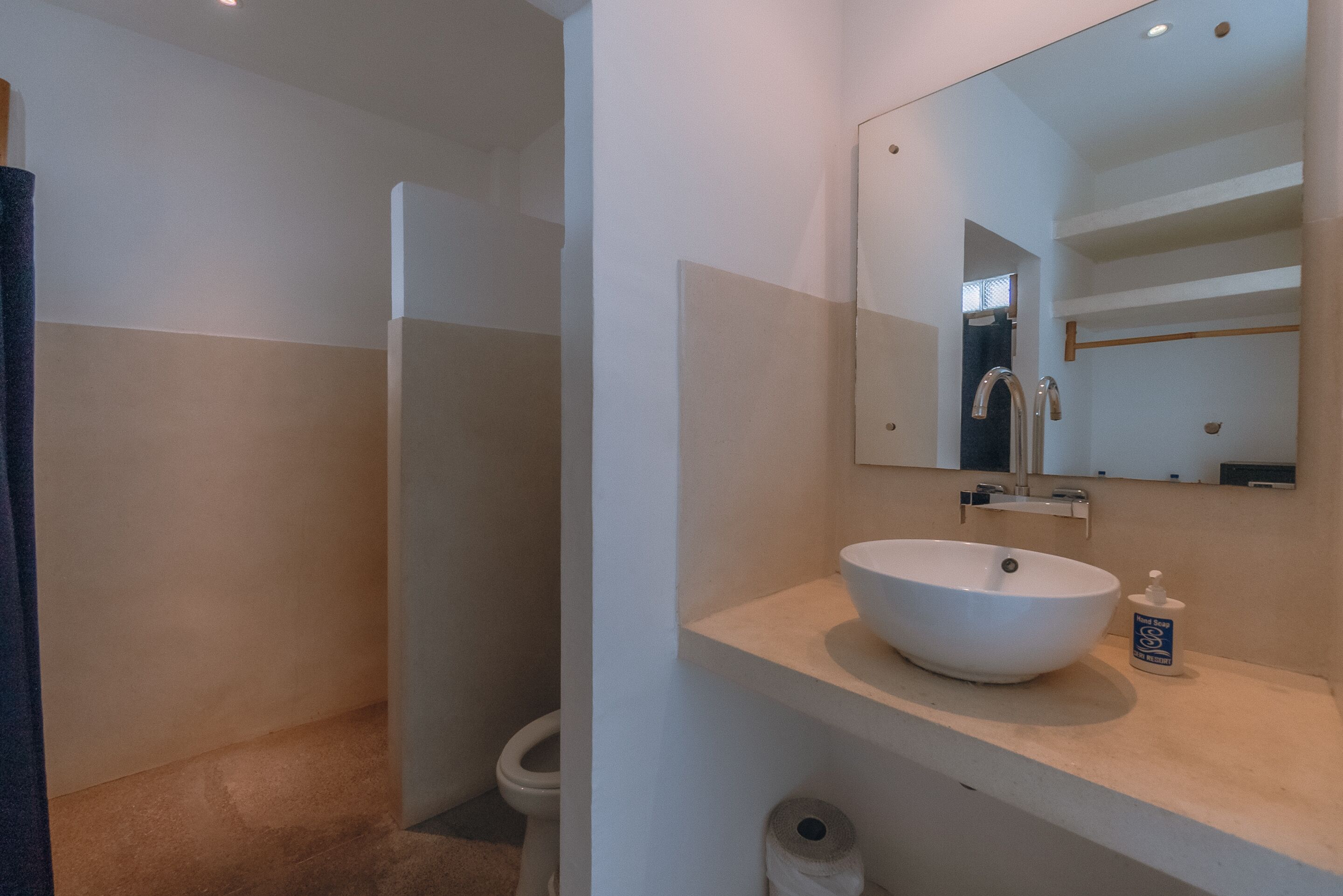 Een badkamer met een groot wastafel, spiegel en toilet.