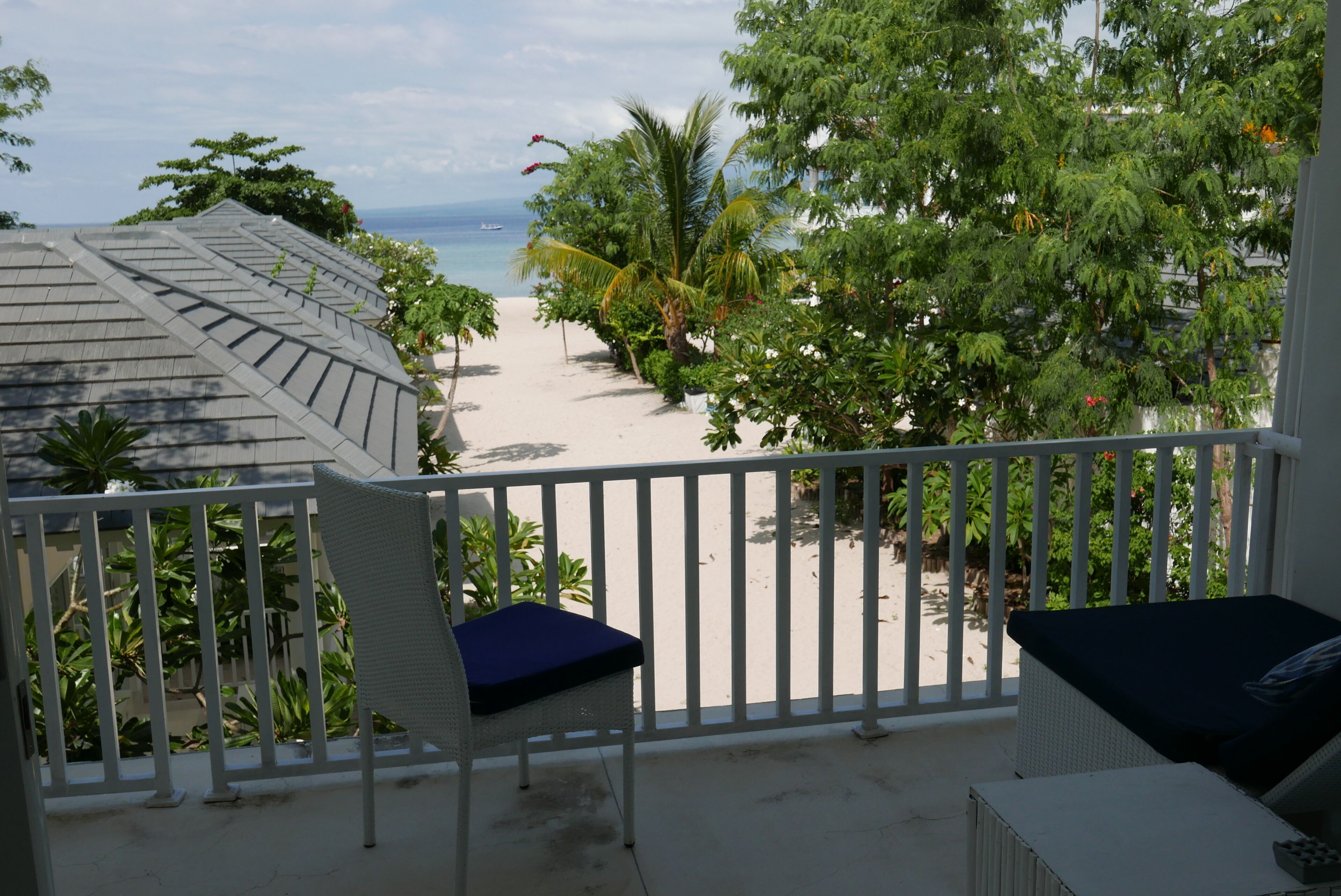 A balcony with a view of a beach and ocean.