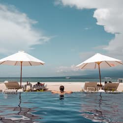 Alberca al aire libre, sombrillas en la alberca y camastros