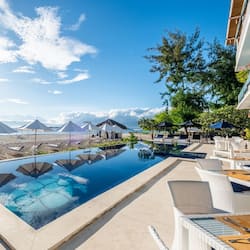 Alberca al aire libre, sombrillas en la alberca y camastros