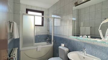 A bathroom with a bathtub, toilet, and sink.