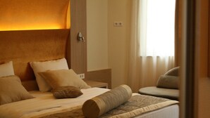 Een hotelkamer met een groot bed, een bank en een nachtkastje.