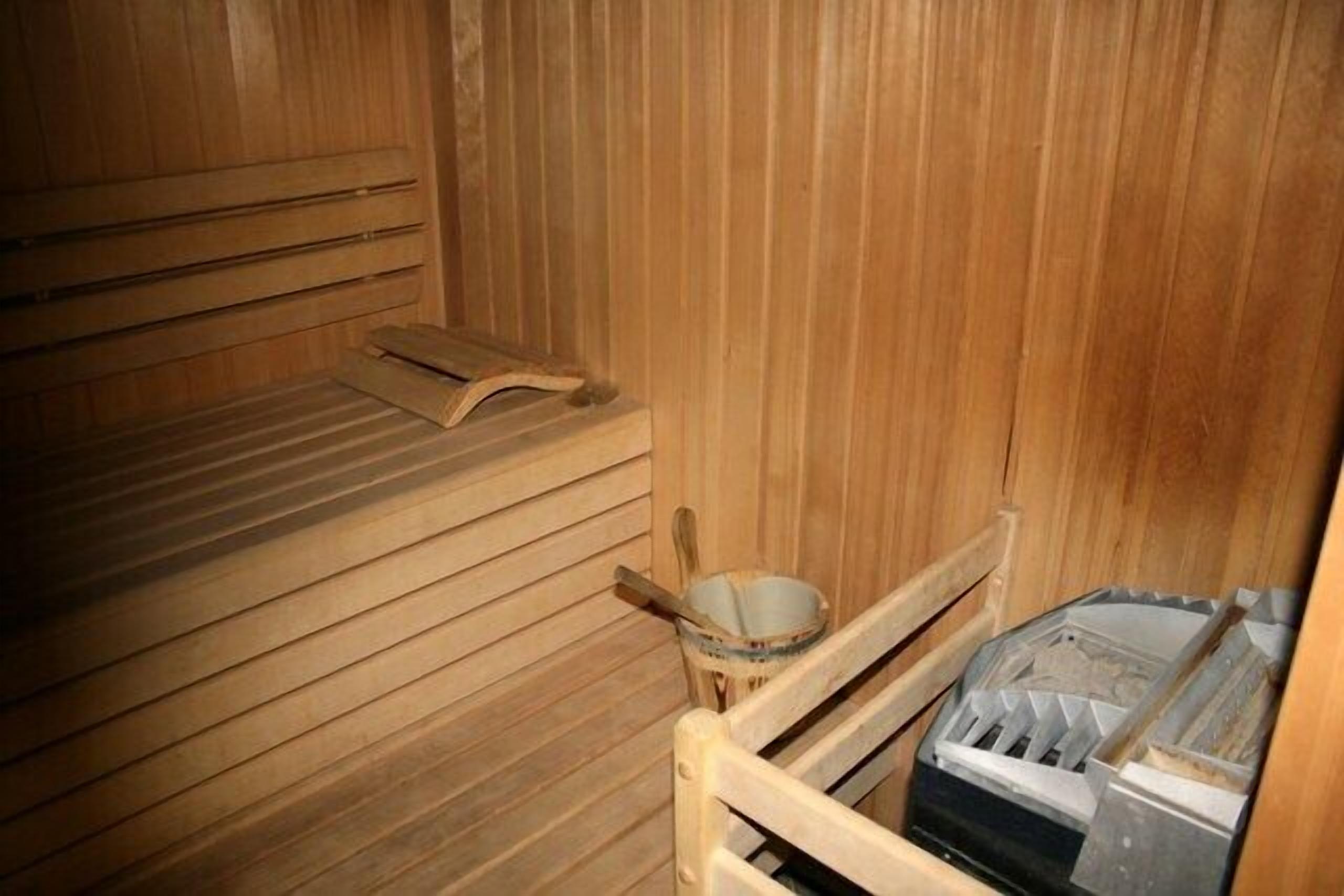 Eine Holzsauna mit Bänken und einem Holzeimer.