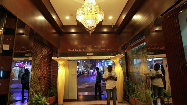 A hotel lobby with a chandelier, potted plants, and a tiled floor. - Mount Royal Hotel (Dubai)