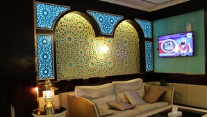 A modern living room with a sofa, a coffee table, and a TV mounted on the wall. - Mount Royal Hotel (Dubai)