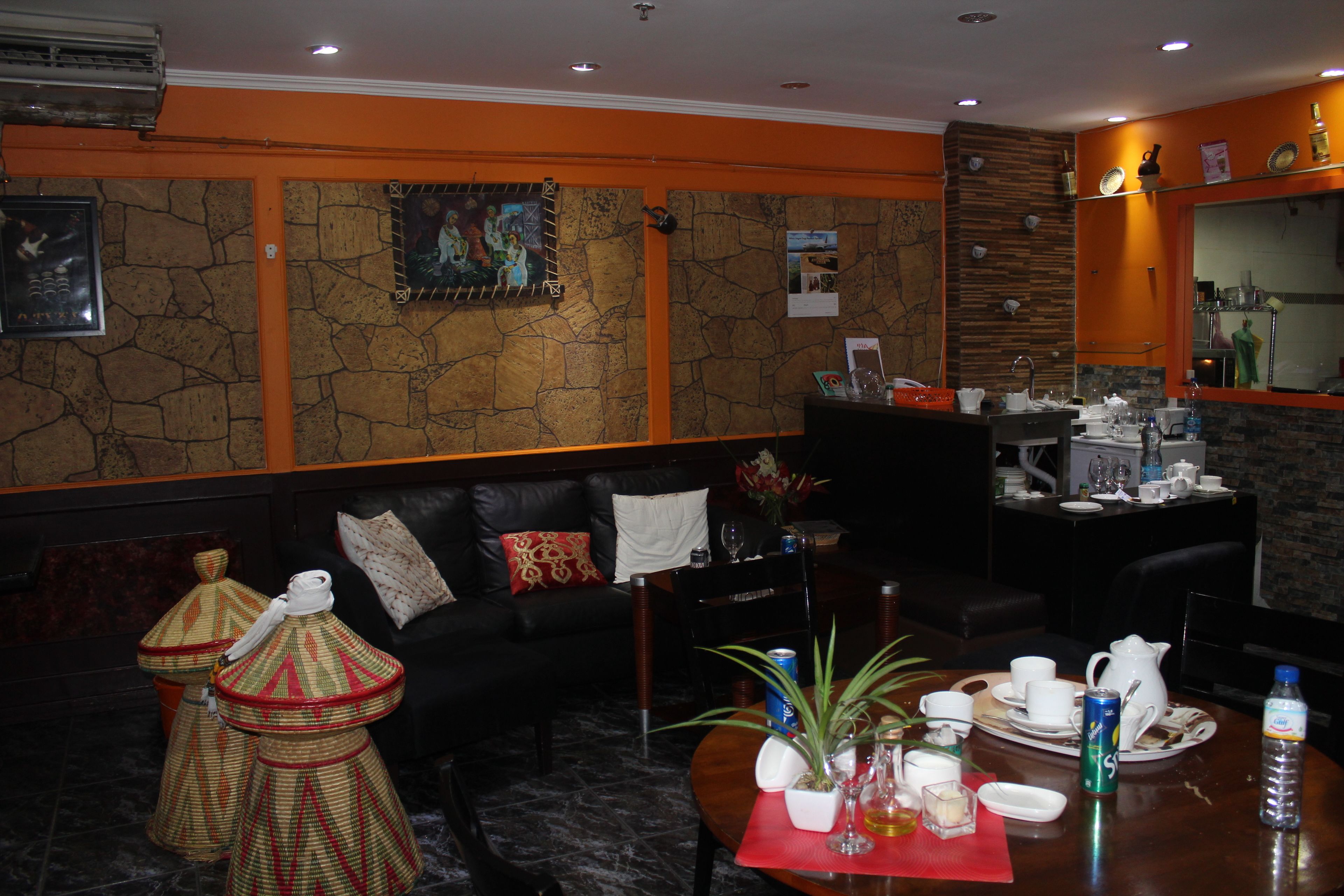 A hotel lobby with a stone wall, a sofa, a coffee table with amenities, and a reception desk.