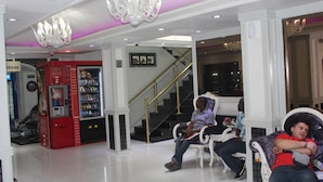 A lobby with a vending machine, a staircase, and seating areas. - White Fort Hotel (Dubai)