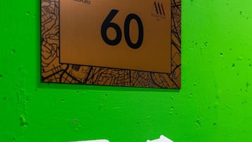Señal en una pared verde con la inscripción 'P3' y '60', e icono de un enchufe blanco.