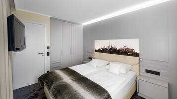 Une chambre d’hôtel moderne avec un grand lit, un téléviseur à écran plat, une œuvre d’art représentant un paysage urbain au-dessus du lit et une petite table de chevet.