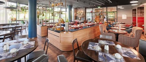 A modern restaurant interior with round tables, bar seating, and a central counter.