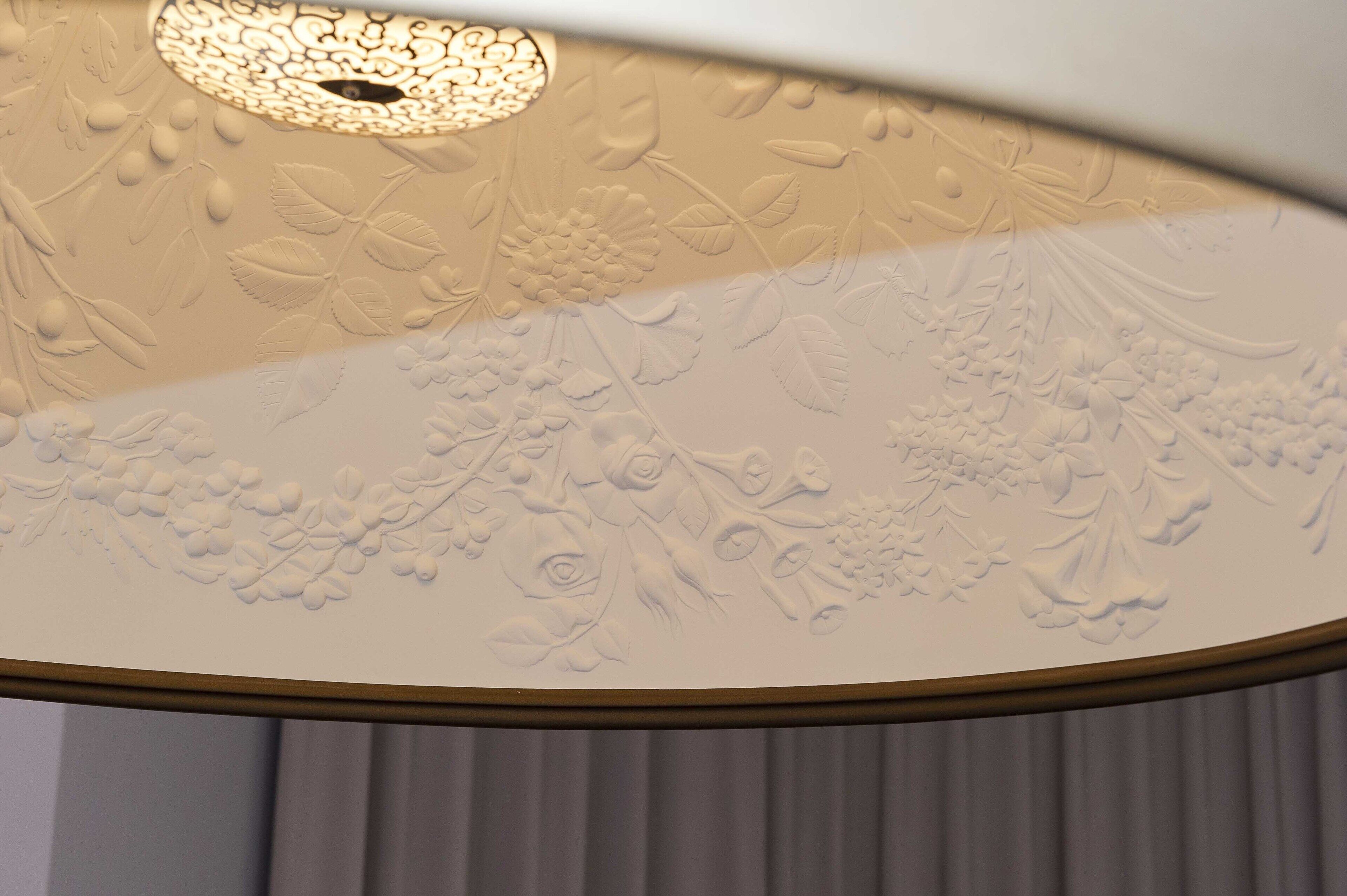 A ceiling with floral and leaf patterns.
