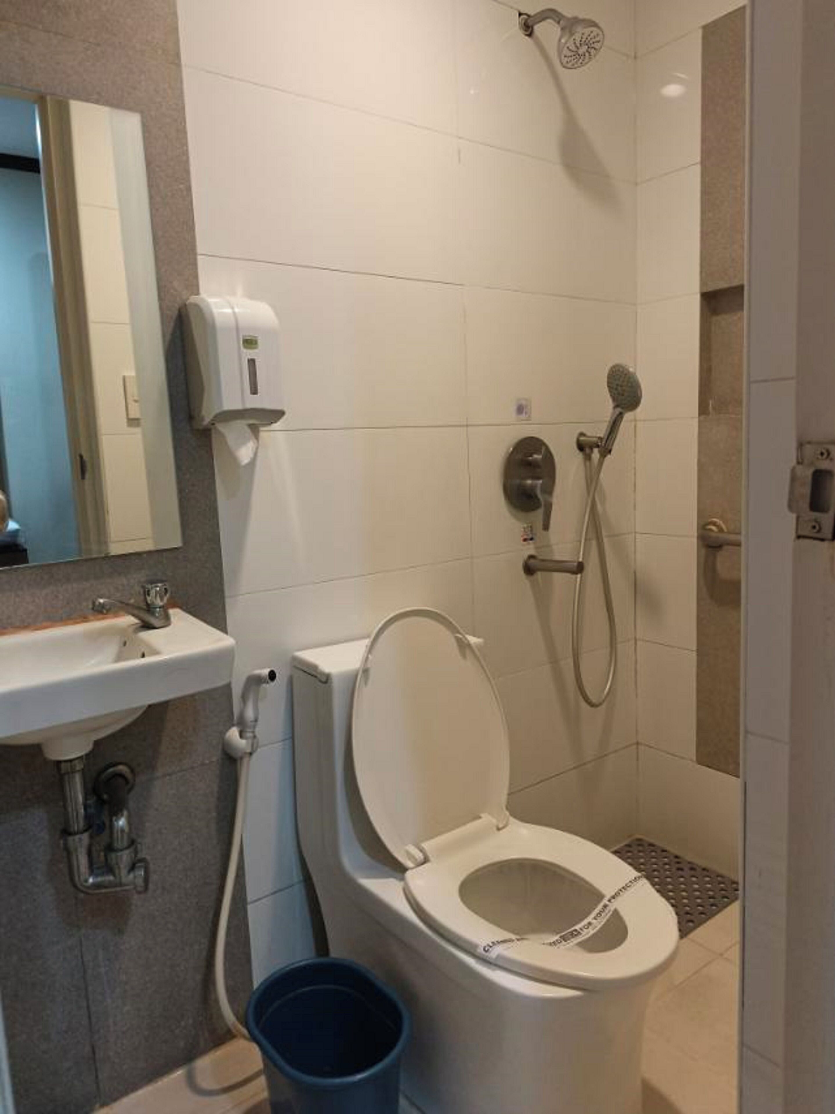 A bathroom with a toilet, sink, and shower.