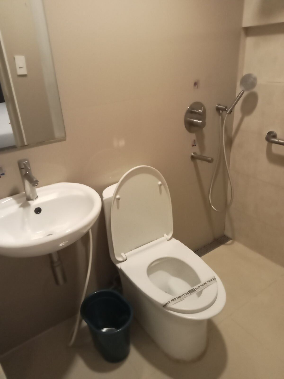 Un baño con lavamanos, inodoro y ducha blancos.