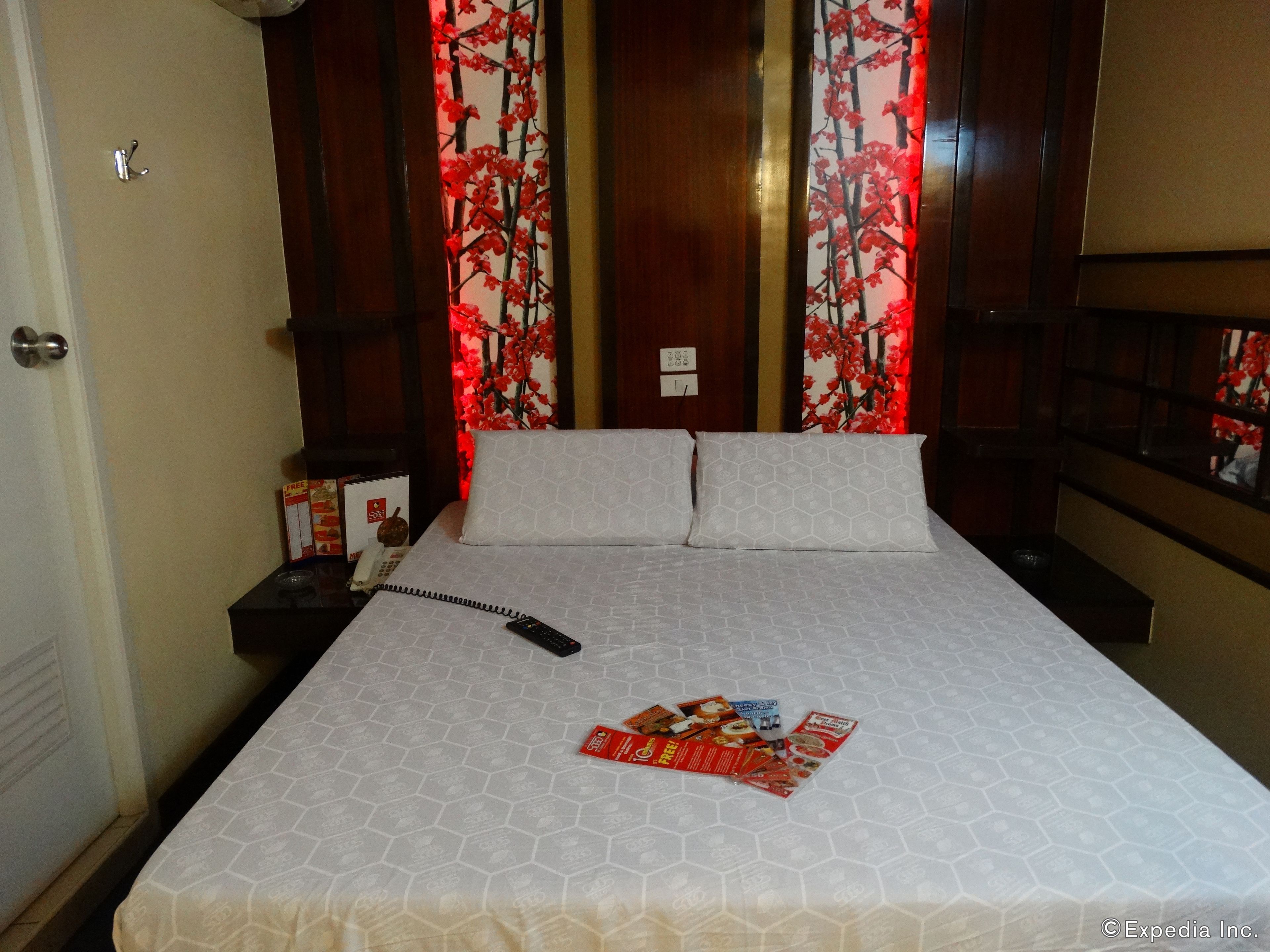 Ein Hotelzimmer mit einem großen Bett, zwei Nachttischen und einer Tür.