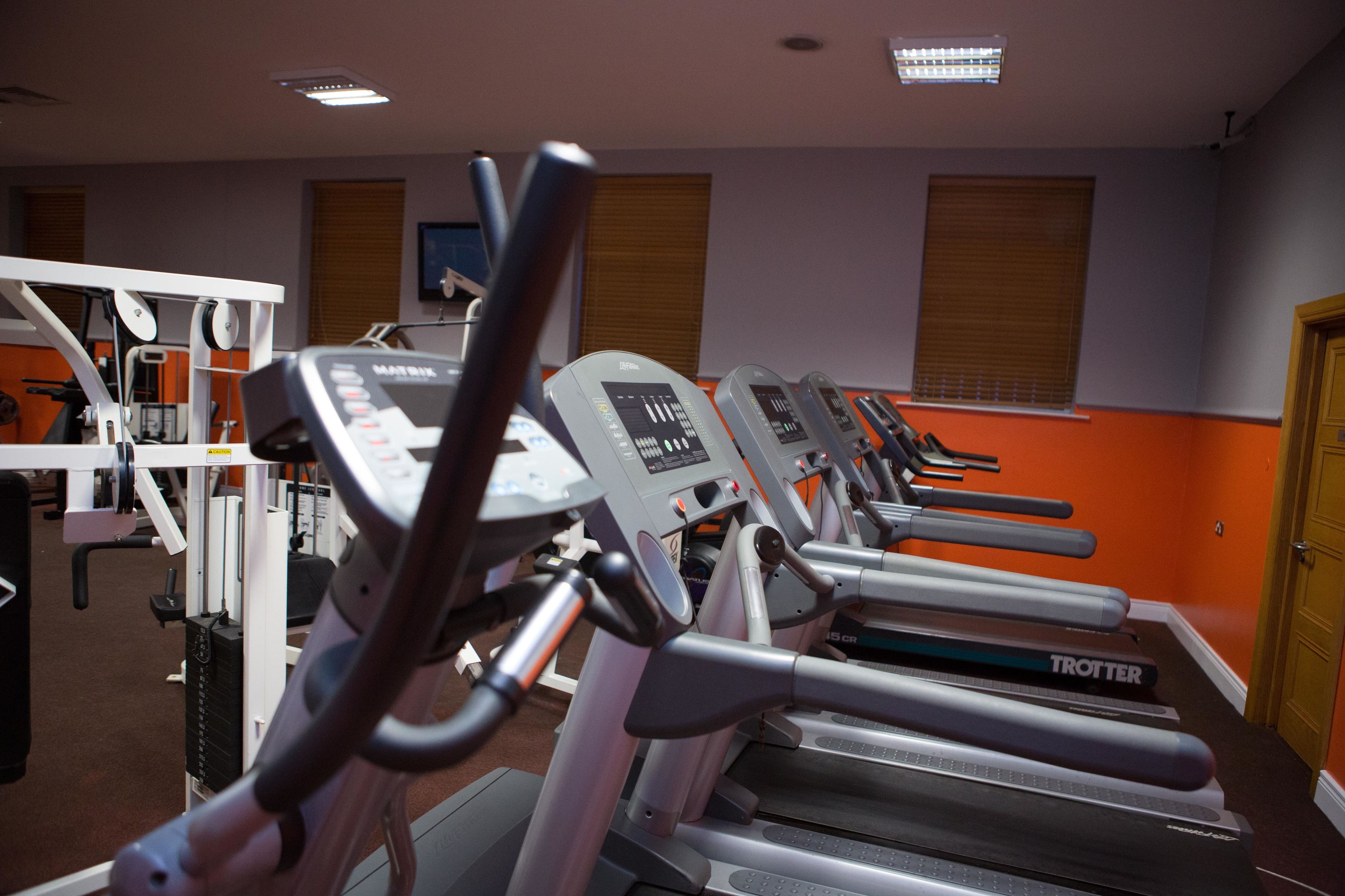 A gym with multiple treadmills and exercise equipment.